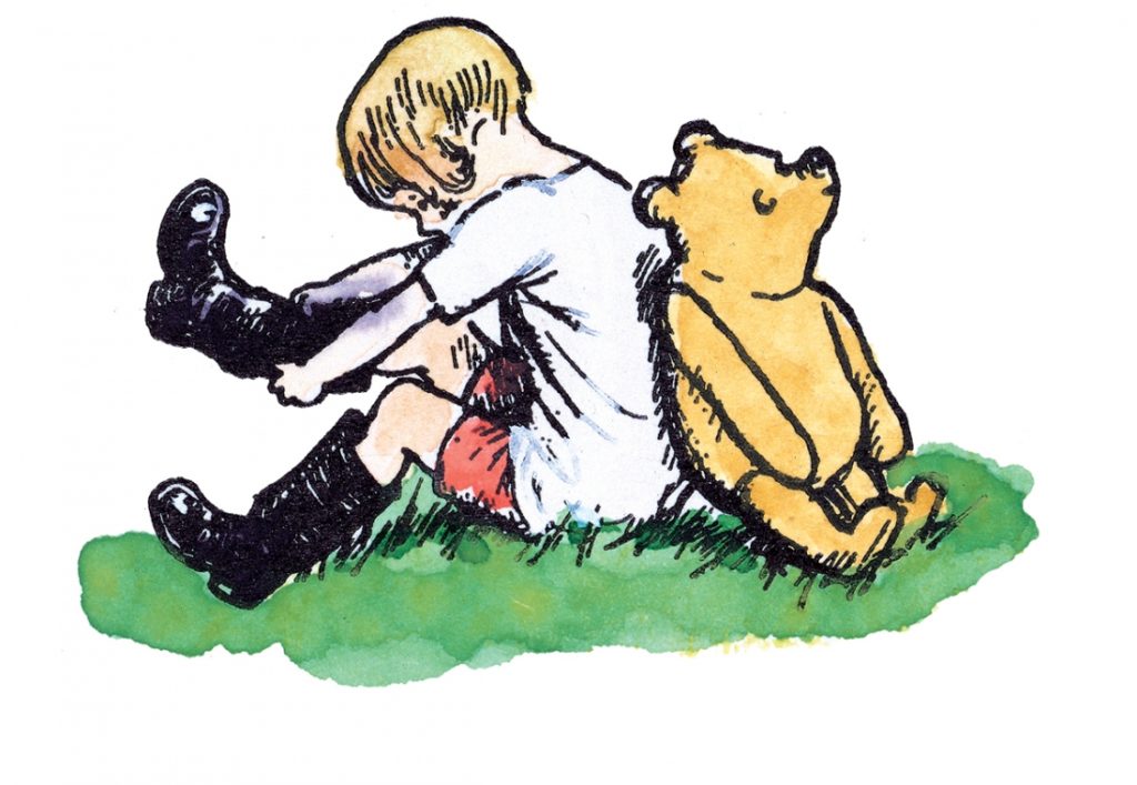 Ein Junge und ein Teddybär sitzen Rücken an Rücken