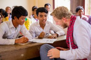 Tim, Mitgründer von Librio, schaut sich Arbeiten von zwei jungen Kambodschanern an
