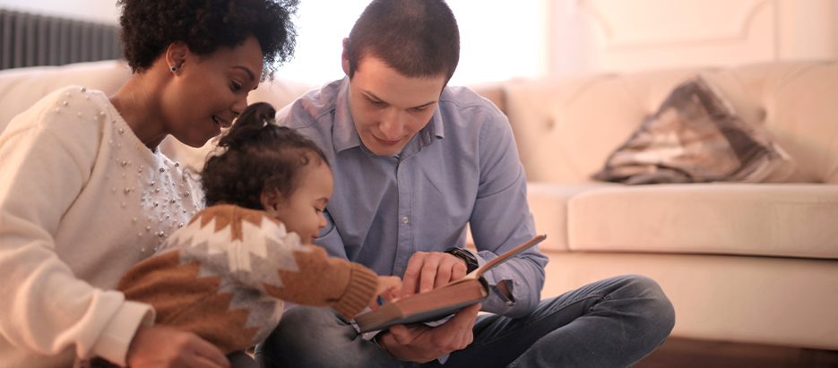 Familia leyendo un cuento con su hija