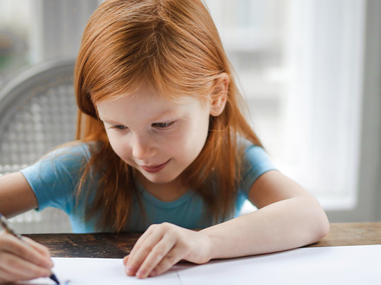 Geschenke zur Einschulung - Ein Mädchen macht die Hausaufgaben