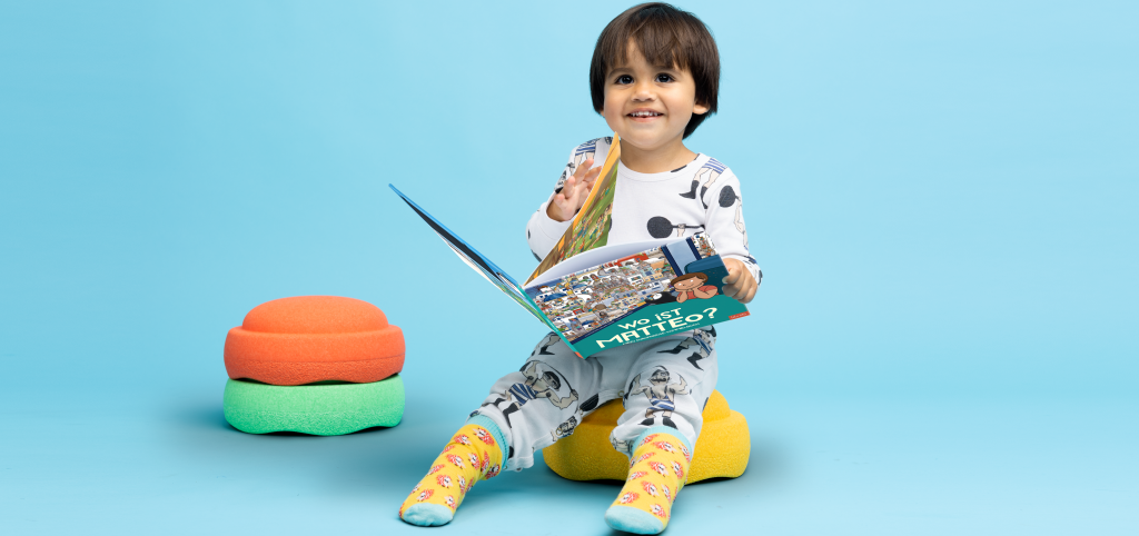 Ein kleiner Junge mit seinem eigenen Wimmelbuch