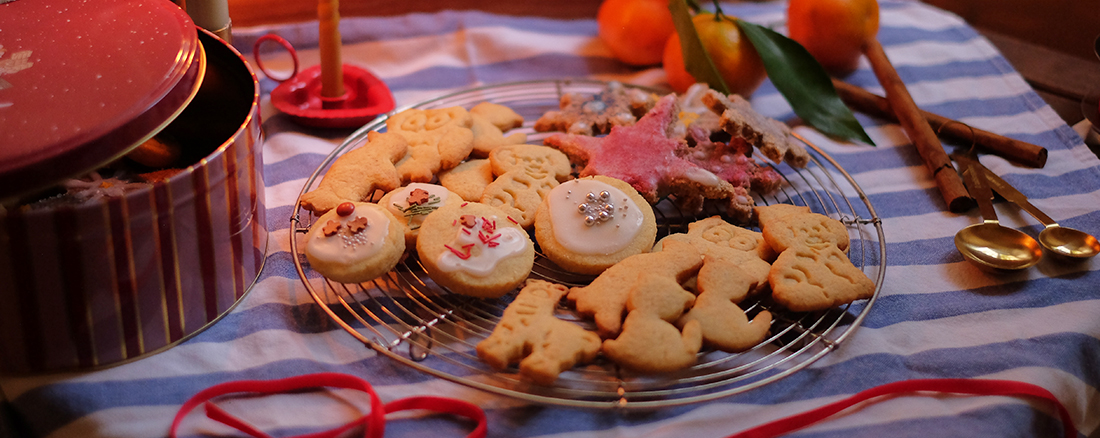 Nahaufnahme eines Tischs bedeckt mit weihnachtlicher Dekoration und verschiedenen Weihnachtskeksen