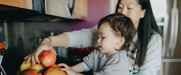 kindliche Sprachentwicklung: Kind mit Äpfeln