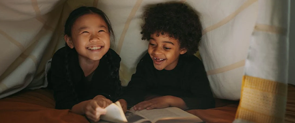 zweisprachige Erziehung: zwei Kinder lesen gemeinsam ein Buch