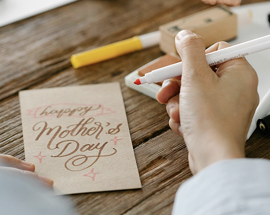 Muttertag, Tochter schreibt Karte "Happy Mother's Day"