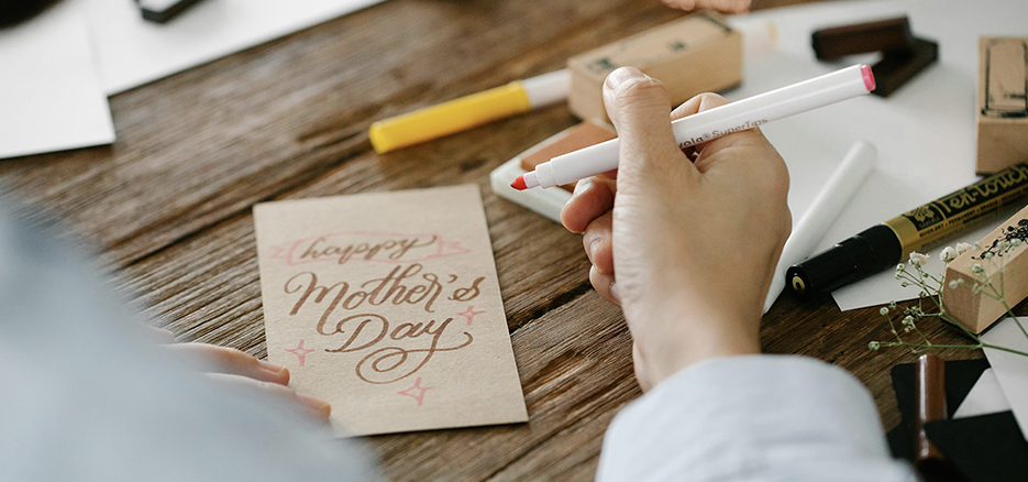 Muttertag, Tochter schreibt Karte "Happy Mother's Day"