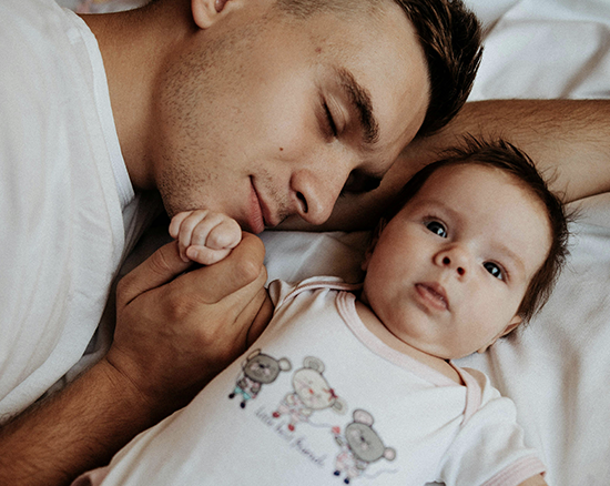 A dad lying down with his little baby