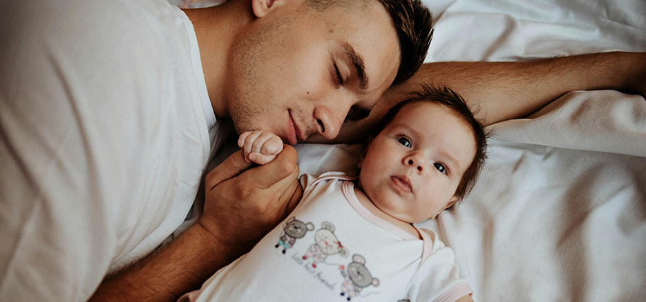 A dad lying down with his little baby