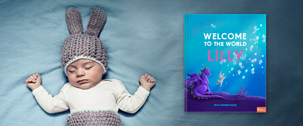 Baby Lilly lying next to her baby book - Welcome to the World